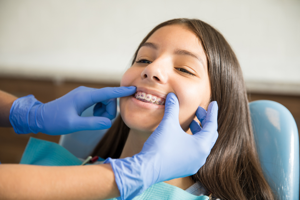Teenage,Girl,With,Braces,Being,Examined,By,Dentist,Wearing,Gloves